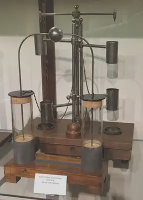 Un modelo de la máquina electrostática con cuentagotas de Kelvin, inventada por el científico escocés [William Thomson (Lord Kelvin)](https://es.wikipedia.org/wiki/William_Thomson) en 1867, expuesta en el [SPARK Museum of Electrical Invention](https://en.wikipedia.org/wiki/SPARK_Museum_of_Electrical_Invention), en Bellingham, Washington, Estados Unidos. Fuente: https://commons.wikimedia.org/wiki/File:Kelvin_water_dropper_electrostatic_machine_model.jpg